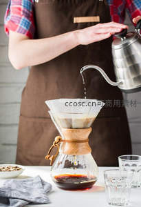 手冲咖啡制作过程特写：热水缓缓注入滤杯萃取咖啡液