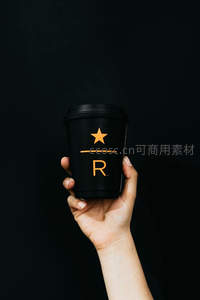 黑底手持瑞幸咖啡杯，金色星标与R字母彰显品牌简约高级感