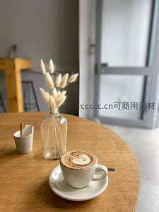 圆木桌上咖啡杯与干花瓶静物组合，简约北欧风