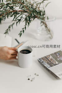 手握白瓷咖啡杯，绿植点缀简约桌面静物