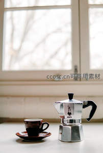 窗边摩卡壶与咖啡杯的冬日静谧组合