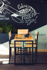 黑板墙咖啡馆角落：木质桌椅与手绘标语