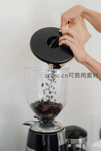 手 pour 咖啡豆入磨豆机：专业手冲前的精准准备瞬间