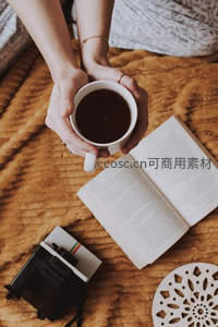 双手捧咖啡杯阅读时光，暖色毛毯与复古相机相伴的惬意午后