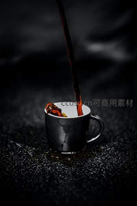 黑釉杯中咖啡倾注瞬间，深色液体飞溅如墨染夜幕