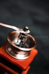复古铜制手摇咖啡磨豆机特写，木质底座与金属光泽交相辉映