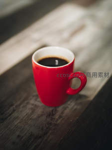 红瓷咖啡杯置于木质桌面特写