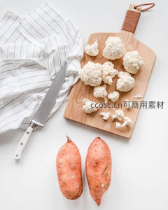 花椰菜切块与红薯静置：木质砧板上的健康食材组合