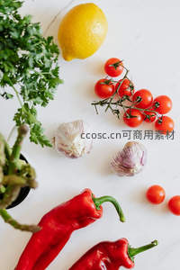 大理石台面上的烹饪原料：柠檬、小番茄与红椒静物组合