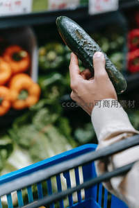 手握带刺青瓜，超市冷柜前选购新鲜黄瓜