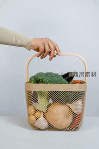 米色网篮盛满新鲜蔬果，手提瞬间展现日常采购温馨感