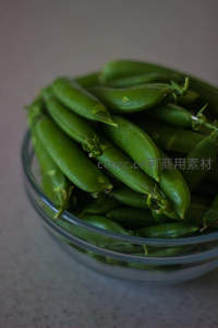 新鲜青豆荚盛于透明玻璃碗中，翠绿饱满，自然光下质感清新