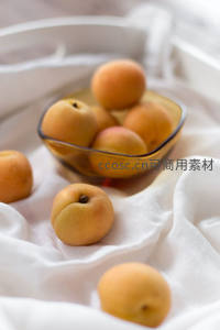 金黄杏子散落白布，琥珀碗中盛放初夏丰收的温柔甜意