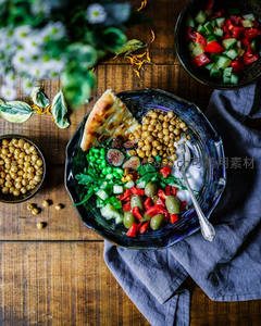 鹰嘴豆沙拉碗配烤饼与新鲜蔬菜，木质桌面静物摄影