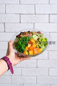 手持透明碗装彩虹沙拉：海藻、南瓜、黄瓜、豌豆与菌菇的活力组合