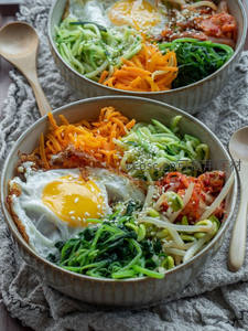 韩式拌饭特写：煎蛋、泡菜、豆芽与芝麻点缀的丰盛碗食