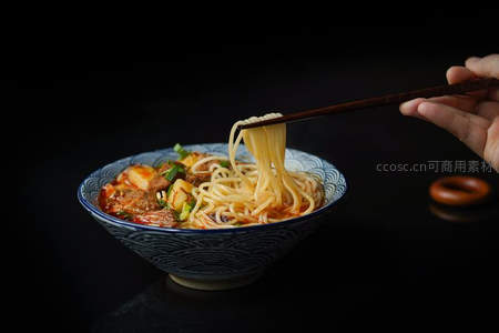 筷子夹起热腾腾牛肉面，青花瓷碗盛满浓郁汤汁与鲜嫩肉块