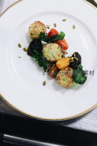 金边白瓷盘上的创意小食拼盘：烤蔬菜、酥皮卷与羽衣甘蓝，厨房台面特写