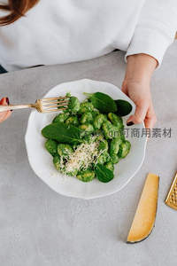 菠菜意式土豆团子配帕玛森芝士，手握白瓷碗特写