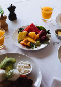 精致早餐拼盘：热带水果沙拉配橙汁与牛油果吐司，白桌布氛围感十足