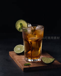 深色背景下冰镇冷萃茶饮，青柠薄荷点缀木质托盘
