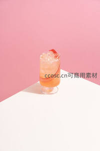 粉橙渐变鸡尾酒置于几何白台，简约风高脚杯特写