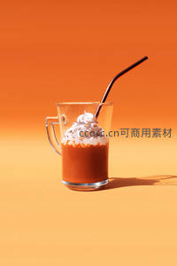橙色渐变背景下的奶油顶热可可，金属弯管增添时尚感