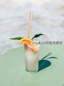 浅绿桌面上冰镇气泡饮，橙片薄荷与竹签装饰，影子生动有趣