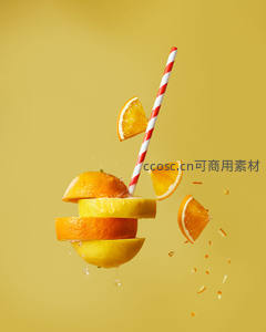 悬浮橙片与红白条纹吸管创意摄影，黄色背景飞溅果汁动感十足