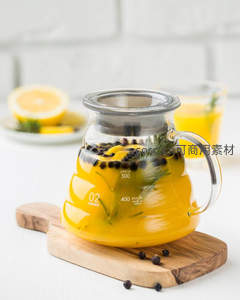 玻璃壶中柠檬百香果冷泡茶，搭配迷迭香与黑胡椒粒，清新健康饮品特写