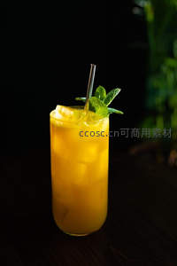 金黄芒果冷萃饮配薄荷与金属吸管，暗背景衬托活力色泽，质感细腻