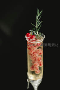 香槟杯中的红醋栗气泡酒，迷迭香枝条优雅点缀