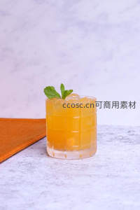 橙色柑橘调酒置于大理石台面，薄荷叶点缀格纹玻璃杯，简约高级感