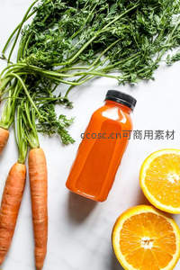 瓶装胡萝卜橙汁俯拍图，搭配带叶胡萝卜与切片橙子