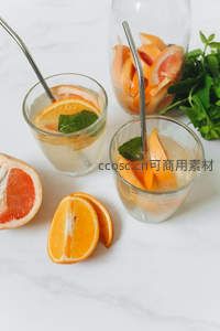 双杯柑橘薄荷气泡饮搭配切开的葡萄柚与橙子，清新摆盘静物图