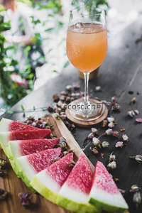西瓜片与玫瑰花茶气泡酒组合，木质托盘上散落干花花瓣