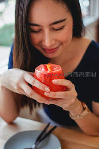 女子轻嗅西瓜雕杯饮品，笑容温婉惬意