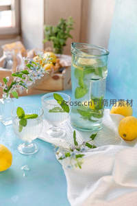 薄荷柠檬水静物摆拍，青蓝桌面配小花枝与木质托盘，清爽解暑