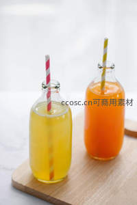 双色玻璃瓶果汁静置木板，条纹吸管增添童趣与夏日氛围
