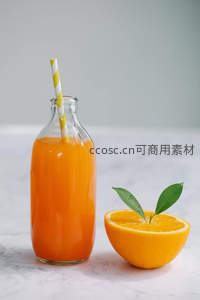 橙汁玻璃瓶配半颗带叶橙子，极简构图展现天然维C活力