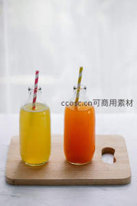 双色玻璃瓶鲜榨果汁，黄橙两色搭配条纹吸管，简约木板摆拍