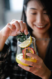 女子微笑装饰饮品，柠檬百香果与迷迭香点缀瞬间