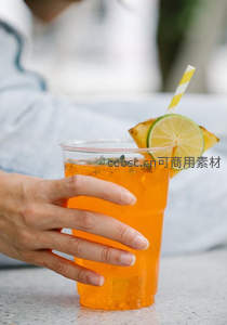 手握橙色气泡饮，柠檬菠萝装饰与黄白条纹吸管增添夏日清新感