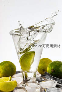 青柠入杯瞬间水花飞溅，冰块环绕，白底背景下动感十足的清凉特写