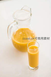 简约白底橙汁特写：玻璃壶与高脚杯中的浓郁鲜榨果汁