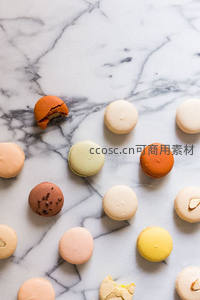 大理石台面散落马卡龙，咬痕与坚果碎展现真实食用感