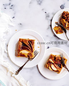大理石台面上的苹果肉桂派切块，搭配复古叉子与纸盘