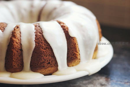 淋面 Bundt 蛋糕特写，浓稠白釉顺流而下显湿润质感