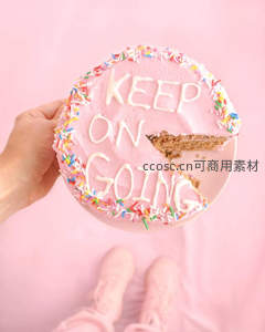 手持粉色蛋糕切片，写着'KEEP ON GOING'励志语句