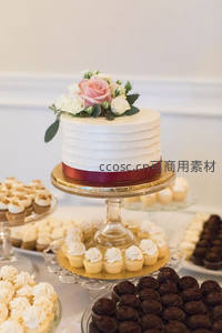 白色奶油蛋糕配粉白玫瑰花饰，红丝带点缀，精致婚礼甜点摆台
